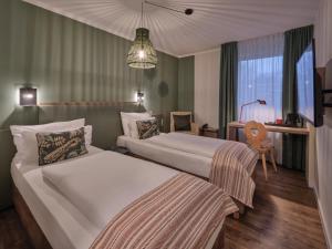 a hotel room with two beds and a desk at Classik Hotel Martinshof, Messe München in Munich +45 photos