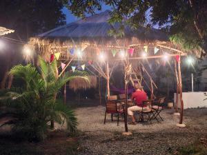 a person sitting at a table under a tent with lights at Zen Space Nesat in Phumĭ Chroŭy Svay
