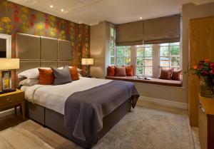 a bedroom with a large bed and a window at Langshott Manor - Luxury Hotel Gatwick in Horley