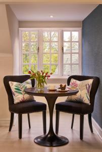 a dining room with a table and two chairs at Langshott Manor - Luxury Hotel Gatwick in Horley