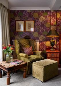 a living room with a couch and a coffee table at Langshott Manor - Luxury Hotel Gatwick in Horley