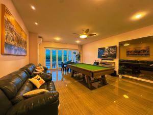 a living room with a couch and a pool table at BBQ,Canoe,KTV, Up to 15 Pax, Entire Villa in Batam Center