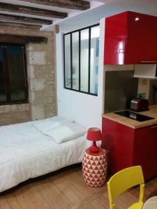 ein kleines Schlafzimmer mit einem Bett und einer Küche in der Unterkunft Tour Duguesclin in Chauvigny