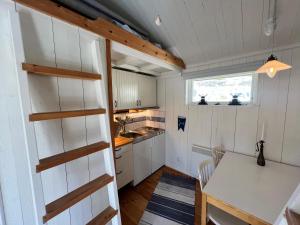 a kitchen with white cabinets and a table and a window at Cozy Studio on Utö Near Beach & Restaurant in Utö