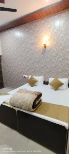 a bedroom with a large bed with white sheets at ANAND LOK VARANASI in Varanasi
