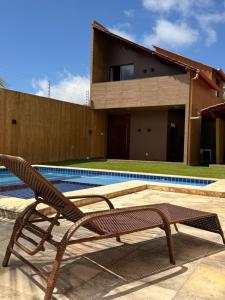 a wooden bench sitting next to a swimming pool at Chalé Ubajara in Ubajara