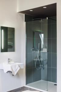a glass shower in a bathroom with a sink at ROMY ANTWERP Sint-Jansvliet in Antwerp +117 photos