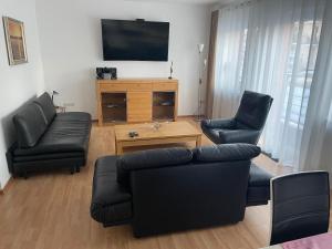 a living room with a couch and two chairs and a tv at Ferienwohnung Nella in Amberg