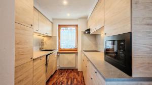 a kitchen with wooden cabinets and a black microwave at Tabia del Caser in San Tomaso +31 photos