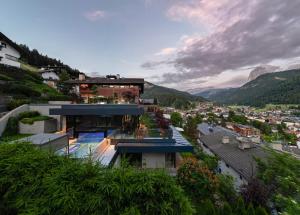 a house on a hill with a view of a city at Gran Tubla Apartments Dolomites in Ortisei