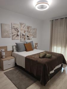 a bedroom with a large bed with paintings on the wall at Las Salinas in Roquetas de Mar