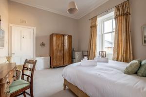 a bedroom with a large white bed and a window at Upper Rocklands - Elie in Earlsferry