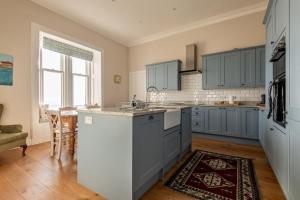 a kitchen with blue cabinets and a counter top at Upper Rocklands - Elie in Earlsferry