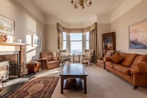 a living room with a couch and a fireplace at Upper Rocklands - Elie in Earlsferry