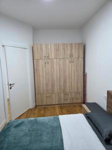a bedroom with a bed and wooden cabinets at Zara in Bar