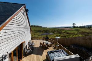 a house with a deck with a table and an umbrella at 3 Bed in Coelbren oc-way238 in Coelbren