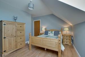 a bedroom with a wooden bed and a dresser at 3 Bed in Coelbren oc-way238 in Coelbren