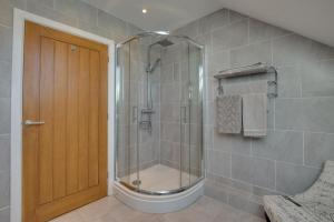 a shower with a glass door in a bathroom at 3 Bed in Coelbren oc-way238 in Coelbren +35 photos