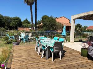 a dining table and chairs on a wooden deck at La Salamandre 66 in Saint-Génis