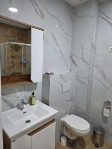 a white bathroom with a toilet and a sink at Zara in Bar +16 photos