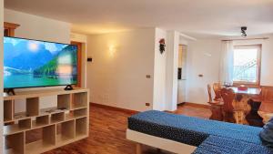 a living room with a large flat screen tv at Tabia del Caser in San Tomaso