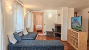 a living room with two blue couches and a television at Tabia del Caser in San Tomaso