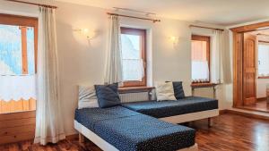a bedroom with two beds and two windows at Tabia del Caser in San Tomaso