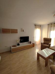 a living room with a tv and a couch and a table at Las Salinas in Roquetas de Mar