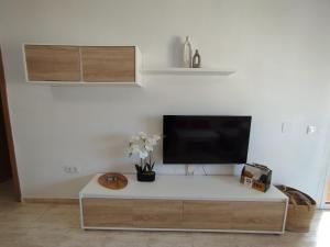 a living room with a tv on a white wall at Las Salinas in Roquetas de Mar +33 photos
