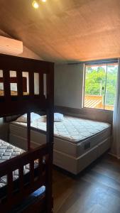 two bunk beds in a room with a window at Chalé Ubajara in Ubajara +90 photos