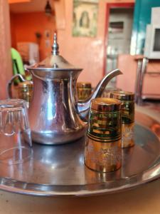 a metal tray with a tea kettle and three candles at Maison Banana in Aourir +6 photos