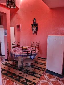 a red room with a table and a refrigerator at Maison Banana in Aourir