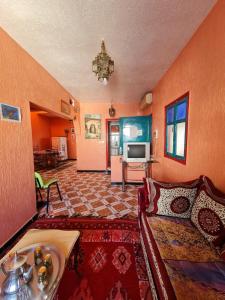a living room with a couch and a television at Maison Banana in Aourir