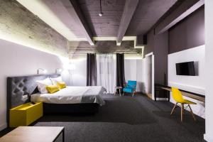 una camera d'albergo con un letto e sedie di Hotel Bohemian Garni - Skadarlija a Belgrado