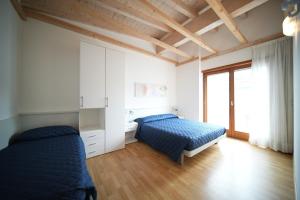 a bedroom with two beds and a window at Bibione MasterVillage Family in Bibione