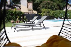 two lounge chairs sitting next to a swimming pool at Primer Peldaño - Casa Quinta in Junín