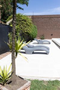 a garden with two white chairs and a tree at Primer Peldaño - Casa Quinta in Junín