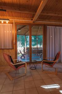 a screened in porch with two chairs and a table at Élet Fája Vendégház in Kemence +30 photos