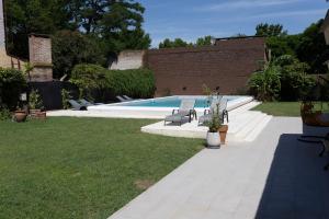 a swimming pool with a bench in a yard at Primer Peldaño - Casa Quinta in Junín