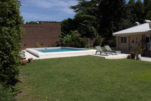 a backyard with a swimming pool and two lawn chairs at Primer Peldaño - Casa Quinta in Junín +19 photos