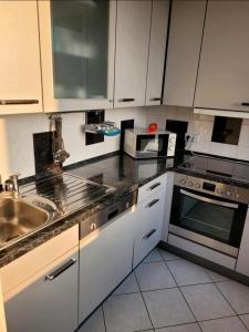 a kitchen with a sink and a stove top oven at Sarra&Mo Ferienwohnung in Duisburg +7 photos