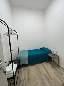 a bedroom with a bed with a blue blanket and a ladder at Salinelle Home in Paterno +19 photos