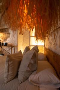 a bed with pillows sitting in a room at Laan Arcos, casa cueva in Arcos de la Frontera +16 photos