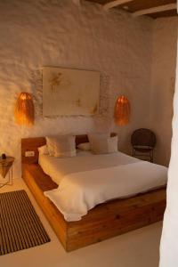 a bedroom with a wooden bed with two lights at Laan Arcos, casa cueva in Arcos de la Frontera
