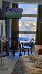 a room with a table and chairs and a large window at Loft 37 Centro histórico in São Paulo