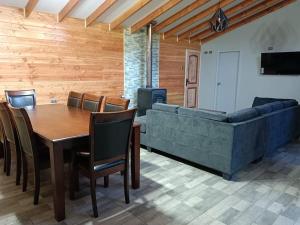 a dining room with a table and a couch at Casa para 8 personas in Licán Ray