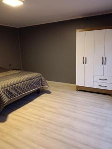 a bedroom with a bed and a white cabinet at Casa para 8 personas in Licán Ray