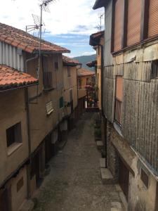 an alley in an old town with buildings at Apartamento Al-Vivaque in Miranda del Castañar +4 photos