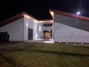 a white house with a garage at night at Casa para 8 personas in Licán Ray