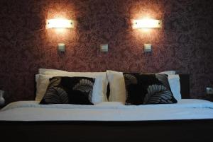 a bedroom with a bed with two lights on the wall at Hotel Porta 26 in Skopje